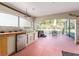Outdoor kitchen with grill, refrigerator, and screened-in patio at 17112 Se 71St Lewisfield Ter, The Villages, FL 32162