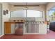 Outdoor kitchen with stainless steel grill, mini-fridge, and tile countertops at 17112 Se 71St Lewisfield Ter, The Villages, FL 32162