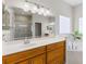 Elegant bathroom featuring dual sinks, wood cabinets, and glass shower at 17350 Se 116Th Court Rd, Summerfield, FL 34491