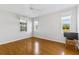Bright bedroom with hardwood floors, ceiling fan, and sun-filled windows at 17350 Se 116Th Court Rd, Summerfield, FL 34491