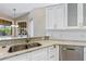 Modern kitchen with white cabinetry, granite countertops, stainless steel appliances, and stylish faucet at 17350 Se 116Th Court Rd, Summerfield, FL 34491