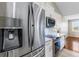 Kitchen with stainless steel refrigerator, microwave, white cabinets, and tiled backsplash at 17350 Se 116Th Court Rd, Summerfield, FL 34491