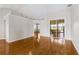 Open living room with hardwood floors and a view of the enclosed patio through glass doors at 17350 Se 116Th Court Rd, Summerfield, FL 34491