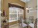 Cozy breakfast nook with glass table, four chairs, and a wine rack at 17716 Se 85Th Ellerbe Ave, The Villages, FL 32162