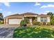 Single-story home with a brown tile roof, attached garage, and manicured lawn at 17716 Se 85Th Ellerbe Ave, The Villages, FL 32162