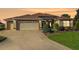Charming one-story home featuring a two-car garage and a beautifully landscaped front yard at sunset at 17716 Se 85Th Ellerbe Ave, The Villages, FL 32162