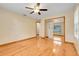 Bright bedroom with hardwood floors, ceiling fan, and mirrored closet at 18033 Rose St, Groveland, FL 34736