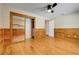 Spacious bedroom featuring a ceiling fan, wood paneling and a sliding door closet at 18033 Rose St, Groveland, FL 34736