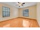 A cozy bedroom with natural light, fan, and hardwood floors at 18033 Rose St, Groveland, FL 34736