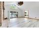 Bright and airy living space with a brick fireplace, vaulted ceilings, and access to the lanai at 18033 Rose St, Groveland, FL 34736