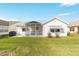 Backyard view showing house exterior, patio, and lawn at 1904 De Hoyos Pl, The Villages, FL 32159