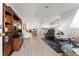 Open-concept living room with wood-look flooring and vaulted ceilings flows into the dining and kitchen areas at 1904 De Hoyos Pl, The Villages, FL 32159