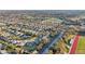 Community overview showcasing numerous homes, golf course, lake, and school at 2486 Five Forks Trl, The Villages, FL 32162
