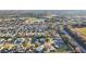 Community overview showcasing numerous homes, golf course, lake, and school at 2486 Five Forks Trl, The Villages, FL 32162