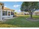 Large backyard with a screened porch and a large tree at 2486 Five Forks Trl, The Villages, FL 32162