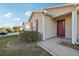 House entrance with red door and manicured landscaping at 2486 Five Forks Trl, The Villages, FL 32162