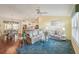 Bright living room with hardwood floors, comfy sofas, and a ceiling fan at 2486 Five Forks Trl, The Villages, FL 32162