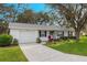 Front view of a white house with a lawn at 26117 Newcombe, Leesburg, FL 34748