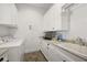 Laundry room with white cabinets, sink, and herringbone tile floor at 2746 Se 19Th Ct, Ocala, FL 34471