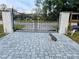Black wrought iron gates with gray brick pavers at 3180 Sixma Rd, Lake Helen, FL 32744