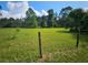 Vacant lot with grassy area, trees, and wooden fence at 3180 Sixma Rd, Lake Helen, FL 32744