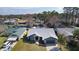 Aerial view of a gray home with a two-car garage in a neighborhood near a lake at 35534 Quail Run, Leesburg, FL 34788