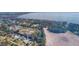 Scenic aerial shot of a lakeside neighborhood showcasing houses with water access and a vast lake beyond at 35534 Quail Run, Leesburg, FL 34788