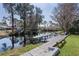 Picturesque waterfront backyard featuring a wooden dock, calm water, and verdant lawn at 35534 Quail Run, Leesburg, FL 34788