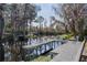 Lush backyard on the water features a private dock and tranquil, natural surroundings with hanging Spanish moss trees at 35534 Quail Run, Leesburg, FL 34788