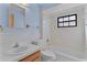 Updated bathroom with light blue walls, white tile, and window over the bathtub at 35534 Quail Run, Leesburg, FL 34788