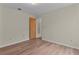 Bedroom has wood-look flooring, neutral paint, and a door at 35534 Quail Run, Leesburg, FL 34788