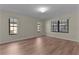 Bright bedroom features wood-look flooring, neutral paint, and multiple windows for ample natural light at 35534 Quail Run, Leesburg, FL 34788