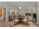 Cozy dining area with a wood table, chandelier, and a large window at 35534 Quail Run, Leesburg, FL 34788