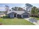 Single story home with a two-car garage, manicured lawn, and mature landscaping at 35534 Quail Run, Leesburg, FL 34788