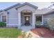 Charming home entrance with arched portico, decorative door, and manicured landscaping at 35534 Quail Run, Leesburg, FL 34788