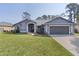 Charming single-story home with a well-maintained lawn, neutral gray paint, and attached two car garage at 35534 Quail Run, Leesburg, FL 34788