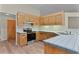 Bright kitchen featuring wooden cabinets, stainless steel appliances, and a tiled countertop at 35534 Quail Run, Leesburg, FL 34788