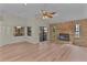 Living room featuring wood-look floors, brick fireplace, and access to the backyard at 35534 Quail Run, Leesburg, FL 34788