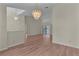 Open-concept living area with hardwood floors, a large chandelier, and sliding glass doors at 35534 Quail Run, Leesburg, FL 34788