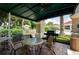 Covered patio with grill, tables, and chairs near pool at 3610 Rollingbrook St, Clermont, FL 34711