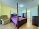 Bright bedroom with a post bed, dresser, and an ensuite bathroom at 3610 Rollingbrook St, Clermont, FL 34711