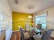 Dining area with yellow wall, glass table, and four chairs at 3610 Rollingbrook St, Clermont, FL 34711