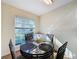 Cozy dining area with glass table and four chairs, near kitchen at 3610 Rollingbrook St, Clermont, FL 34711