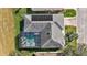 Aerial view featuring screened pool and solar panels on the roof of this beautifully landscaped home at 3839 Manor Oaks Ct, Leesburg, FL 34748