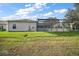 Backyard view of house with grassy area and screened pool at 3839 Manor Oaks Ct, Leesburg, FL 34748