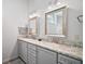 Bathroom with dual sinks, gray cabinets, and a granite countertop offers style and functionality at 3839 Manor Oaks Ct, Leesburg, FL 34748
