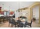 Open dining area with glass-top table and eight chairs at 3839 Manor Oaks Ct, Leesburg, FL 34748