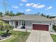 Charming single-story home with a well-manicured lawn, two car garage and inviting front entrance at 3839 Manor Oaks Ct, Leesburg, FL 34748