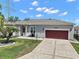 Charming single-story home with a well-manicured lawn, two car garage and inviting front entrance at 3839 Manor Oaks Ct, Leesburg, FL 34748
