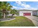 Beautiful single-story home with a well-manicured lawn, palm trees, and a two-car garage at 3839 Manor Oaks Ct, Leesburg, FL 34748